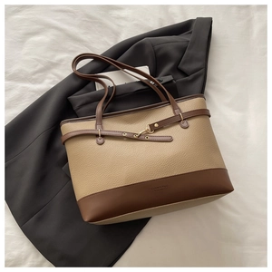 Detailed macro view of large contrast-color tote bag featuring premium pebble leather texture