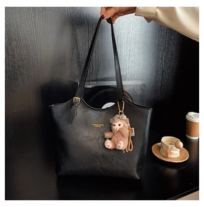 Detail of black faux leather tote with retro texture and FASHION & BAGS lettering