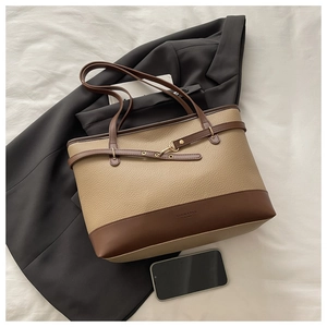 Detail of khakhi large tote bag with brown straps and textured litchi leather finish