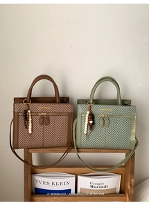 Detail of woven texture on brown and sage green tote bags with beaded charms and straps