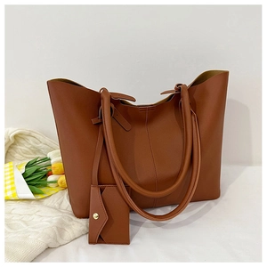 Brown PU leather tote bag set with a small matching pouch in a cozy lifestyle setting