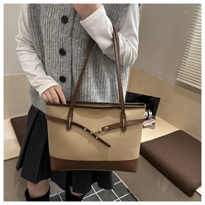 Detail of khaki tote bag featuring premium lychee texture and adjustable brown strap buckle
