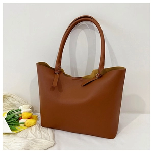 Detailed view of a large brown faux leather tote bag with stylish tie straps