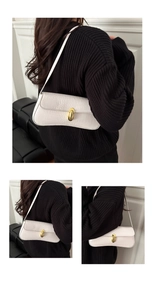 Detail of white crocodile pattern baguette bag with gold buckle and slim shoulder strap