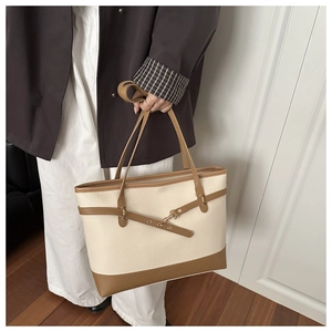 Detail of lychee pattern faux leather tote bag with stylish metal buckle and logo