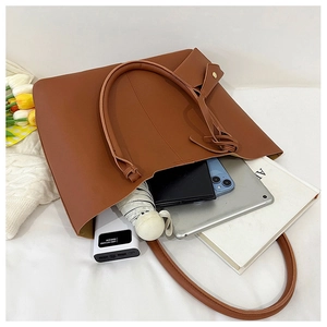 Brown leather tote bag showing large capacity for tablet, umbrella, and daily essentials