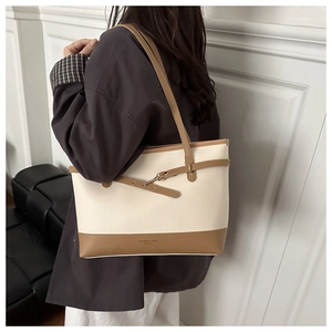 Side view of white and brown contrast tote bag featuring pebble grain texture and straps