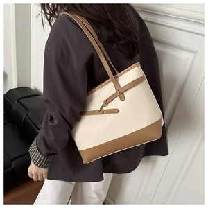 Side view of contrast stitch tote bag on shoulder with creamy leather and brown straps