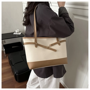 Detail of contrast color tote bag with pebble leather texture and fashion lettering