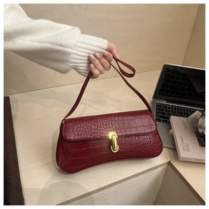 Close-up of deep red crocodile embossed leather with a luxury gold metal buckle