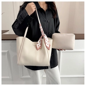 Große beige Tragetasche und Etui mit dekorativem Seidenschal am Griff am Modell