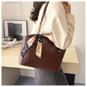 Close-up of brown crocodile pattern tote bag featuring a decorative printed silk scarf
