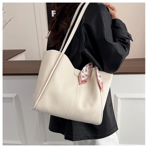Cremeweiße Shopper-Tasche mit gepunktetem Halstuch als Schultertasche im Raum getragen