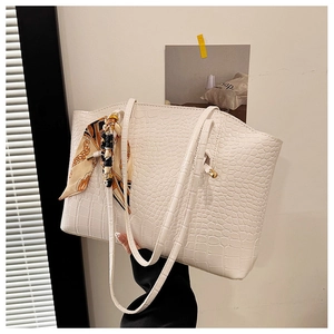 Close-up of white faux crocodile leather tote bag featuring a decorative printed silk scarf