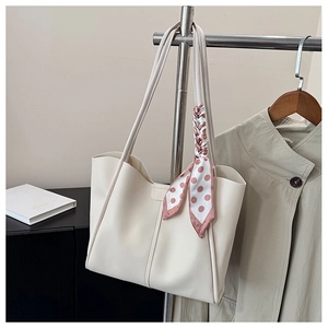 Detail of cream tote bag featuring a decorative polka dot scarf and premium PU leather texture