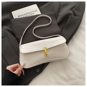 Close-up of white crocodile pattern embossed leather bag with gold metal buckle