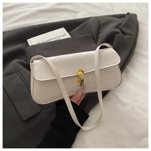 Detail of white crocodile embossed baguette bag with elegant gold metal buckle clasp