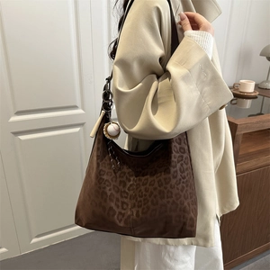 Brown leopard print hobo bag for women with wide strap and baseball pendant
