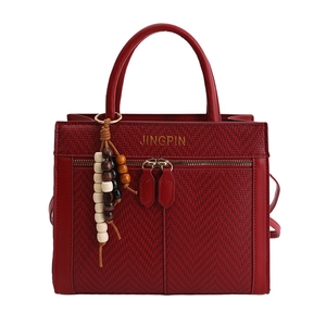 Dark red herringbone woven tote bag with leather trim and decorative wooden bead tassel