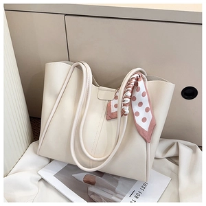 Detail of cream tote bag with fine PU leather texture and decorative polka dot scarf
