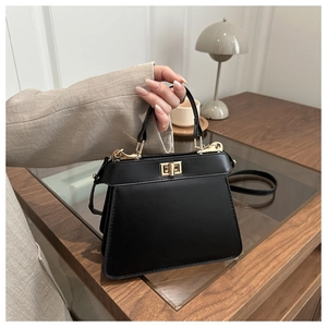 Detail of elegant black leather handbag with gold twist lock and sturdy top handle