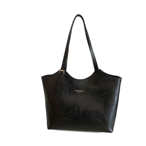 Minimalist black tote bag with vintage marble texture and gold metal buckle on shoulder strap