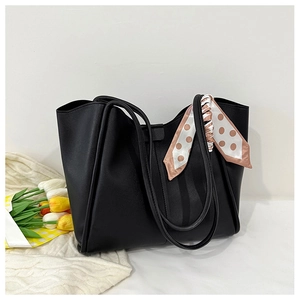 Close-up of black leather tote bag featuring a pink polka dot scarf and tulip decoration