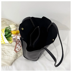Interior view of black tote bag showing large capacity compartment and polka dot scarf detail