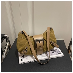 Dettaglio borsa vintage in tela senape con finiture in pelle e fibbia metallica