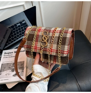 Detailed view of plaid tweed shoulder bag with golden tassel logo and metal chain strap