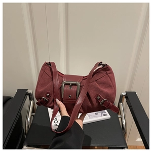 Vue détaillée du sac sous le bras en daim bordeaux avec boucle métallique vintage