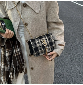 Detail of plaid tweed crossbody bag with gold chain strap and tassel charm decoration