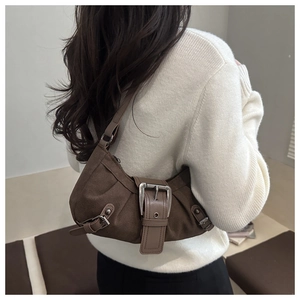 Dettaglio borsa a tracolla vintage in pelle scamosciata marrone con grande fibbia in metallo
