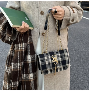 Detailed shot of retro plaid crossbody bag featuring gold S-letter logo and metal chain
