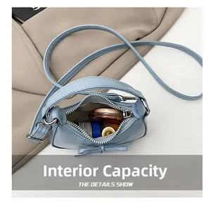 Macro view of blue bow shoulder bag interior showing capacity for lipstick and makeup