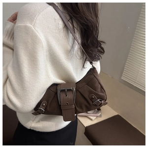 Close-up of a dark brown crescent underarm bag with a large decorative metal buckle detail