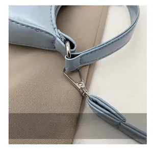 Detailed close-up of premium silver metal hooks and stitching on a light blue leather bag