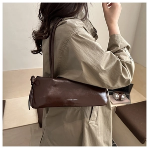 Borsa baguette marrone scuro con stampa Fashion & Bags indossata con un trench beige