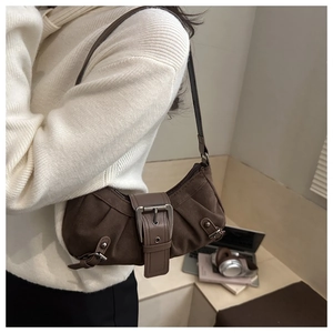 Detail of vintage brown suede underarm bag with metal buckle and pleated sides