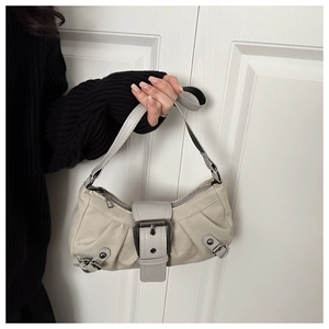 Dettaglio borsa beige vintage con fibbia metallica e borchie punk per donna