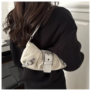 Detail of cream white leather underarm bag with silver buckle accents on shoulder strap