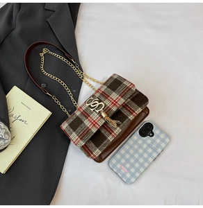 Close-up of vintage plaid handbag with gold tassel buckle and elegant chain strap