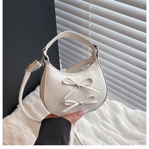 Detail of cream white half-moon bag with 3D bows and adjustable shoulder strap
