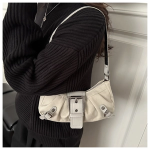 Gros plan du sac baguette blanc crème avec grande boucle argentée et rivets en métal