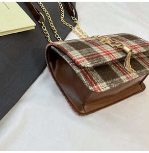 Macro detail of plaid tweed crossbody bag with gold logo charm and metal chain strap