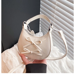 Detailed view of a white PU leather bag with cute double bows and top handle