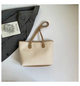 Detailed top view of off-white tote bag with brown straps and buckle detailing