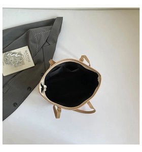 Interior view of khaki tote bag featuring black lining, dual pockets and gold metal buckle