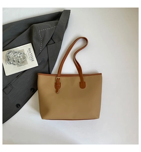 Macro shot of khaki tote bag texture with brown strap and golden buckle on white surface
