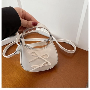 Detail of white semi-circle mini bag with leather bows and fine stitching details